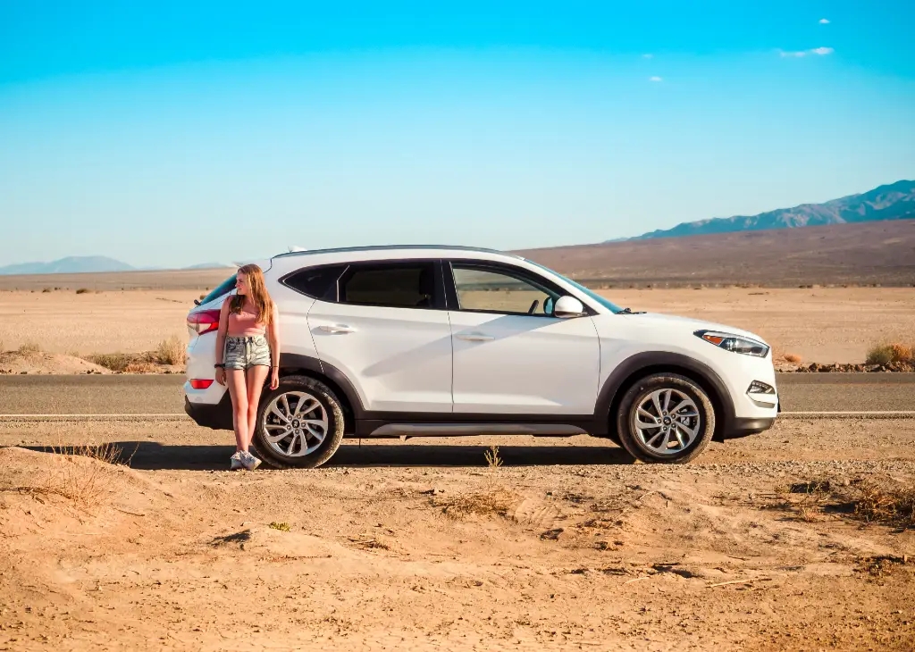 woman standing in front of car by road